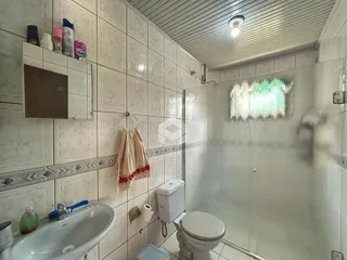 Foto de um banheiro com revestimento cerâmico nas paredes.