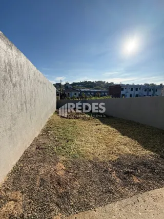 Parede externa de uma propriedade com grama seca no primeiro plano.