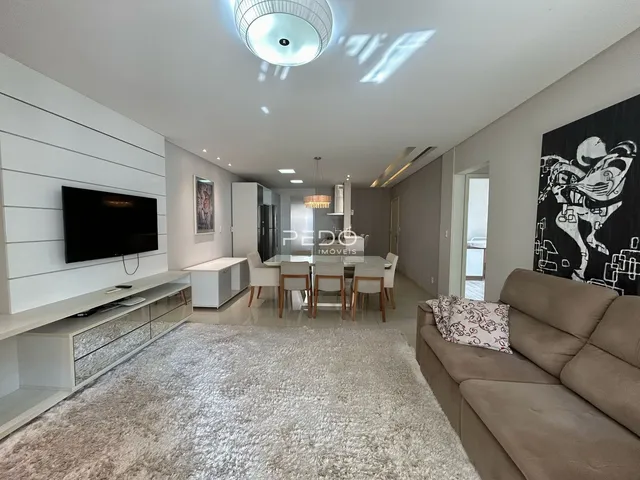 Sala de estar moderna com decoração clara e piso de carpete.