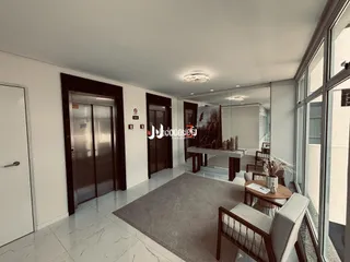 Hall de entrada com portas de madeira e piso claro.