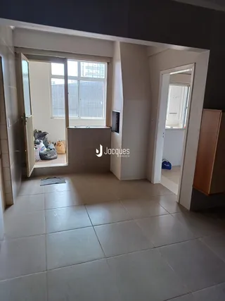 Hall de entrada com piso de cerâmica clara e portas de acesso a outros cômodos.