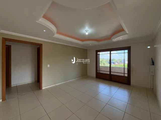 Interior de uma sala com piso de cerâmica e porta de vidro.