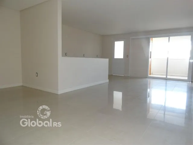Interior de uma sala ampla com piso claro e paredes brancas.