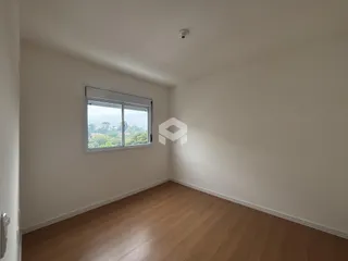 Vista interna de uma sala com piso de madeira e janela.