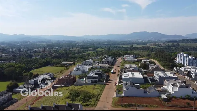 Vista aérea de uma área residencial com casas e campos no entorno de Lajeado.
