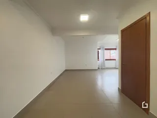 Corredor interno de uma residência com piso de cerâmica.