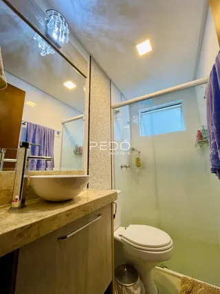 Interior de um banheiro com pia e vaso sanitário.