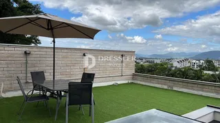 Vista de um quintal com gramado e área de jantar ao ar livre.
