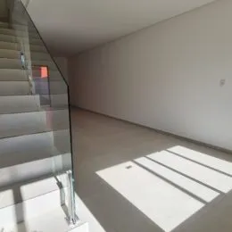 Hall de entrada com escadas e paredes brancas.