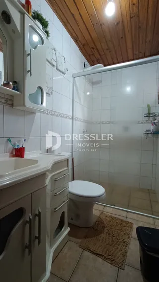 Foto de um banheiro com box de vidro e piso de cerâmica.