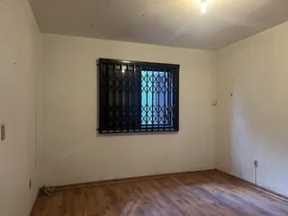 Ambiente interno com paredes brancas e piso de madeira.