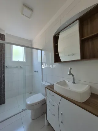 Um banheiro moderno com piso cerâmico e armários de madeira.