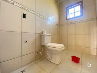 Foto de um banheiro com azulejos brancos e vaso sanitário.
