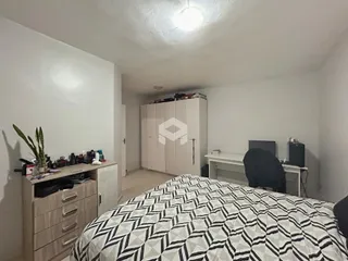 Quarto com armário e cama em ambiente claro.