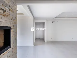 Hall de entrada com parede de pedra e piso claro em ambiente interno.