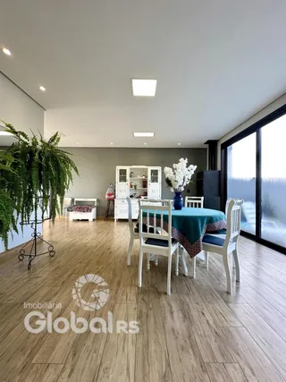 Sala de jantar com piso de madeira e grande janela.