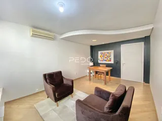 Sala de estar com sofás e decoração em ambiente claro.