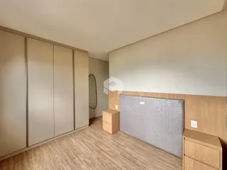 Interior de um quarto com armários embutidos e piso de madeira clara.