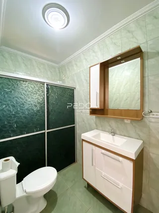 Um banheiro com revestimento verde nas paredes e piso.