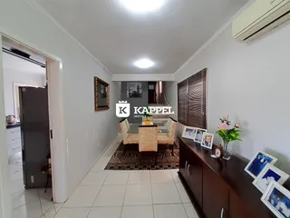Corredor interno com piso claro e móveis de madeira.