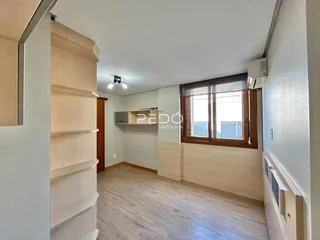 Foto de um ambiente interno com piso de madeira clara e estantes.