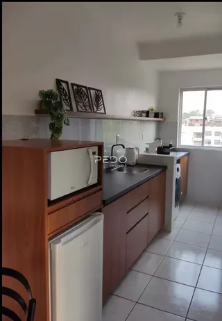 Cozinha com armários de madeira e piso cerâmico.