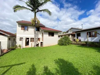 Fachada de casa em Lajeado com jardim verde bem cuidado.