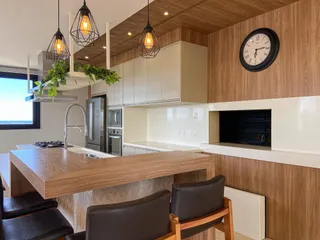 Cozinha moderna com bancada de madeira e iluminação pendente.