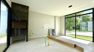Uma sala de estar com lareira e grande janela de vidro.