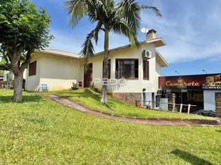 Fachada de uma casa com jardim gramado e árvores em Lajeado.