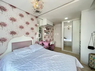 Quarto com cama e armários em um ambiente claro.
