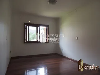 Uma sala de estar com piso de madeira e janela.