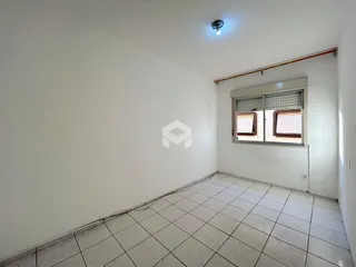 Interior de um ambiente com piso de cerâmica e paredes brancas.