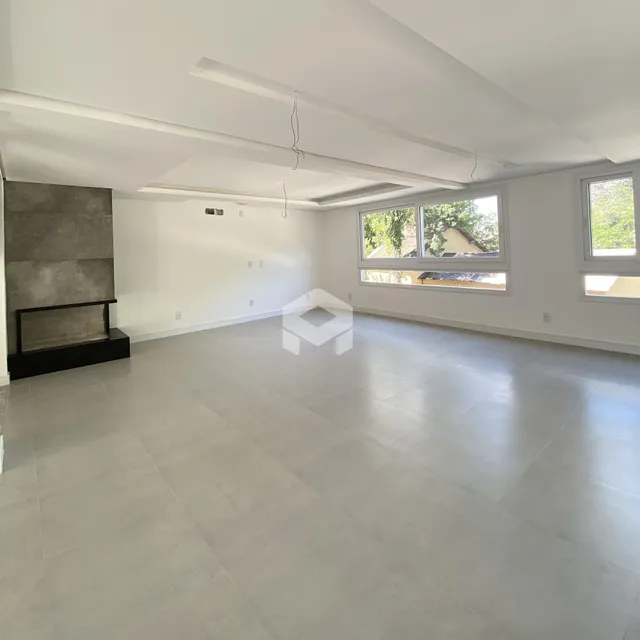 Sala ampla com piso de grande formato e lareira de pedra.