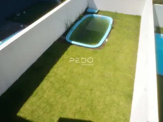 Foto de uma área externa com gramado e piscina.