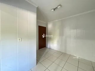 Hall de entrada com piso de cerâmica e paredes brancas.
