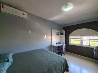 Quarto com cama e janela arqueada na sala.