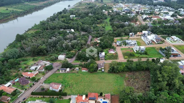 Vista aérea de uma área rural com rios e residências no Brasil.