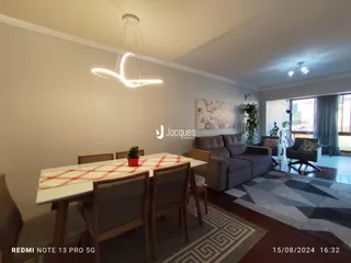 Sala de estar com sofá e mesa de jantar em um imóvel no Brasil.