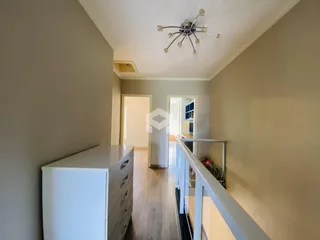 Hall de entrada com piso de madeira e paredes claras.