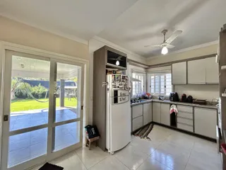 Sala de estar e cozinha com portas de vidro que dão acesso a um pátio externo.