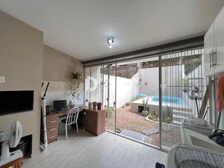 Sala de estar com acesso a um pátio externo com piscina.