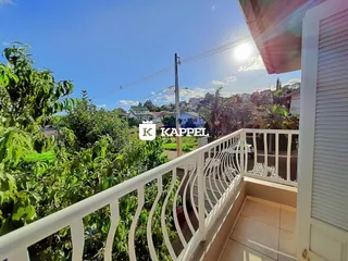 Vista da varanda com vegetação exuberante ao fundo.