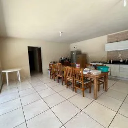 Ambiente interno com mesa de madeira e piso de cerâmica.