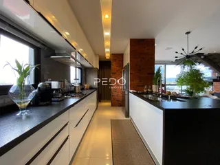 Vista da cozinha moderna com armários brancos e bancada escura.