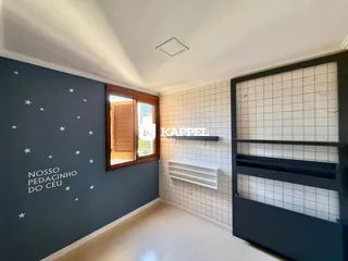 Uma sala de estar com paredes azuis escuras e piso claro.