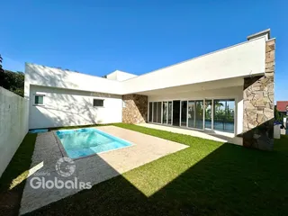 Fachada de casa moderna com piscina e jardim em Lajeado.