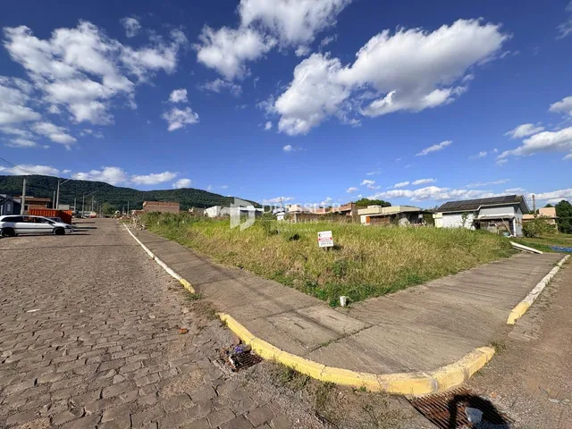 Vista externa de uma propriedade com área gramada e estrada.