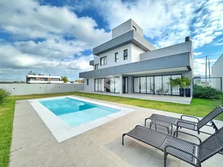 Fachada de casa moderna com piscina e jardim em Lajeado.