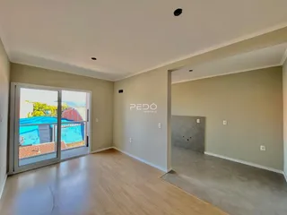 Sala de estar com porta de vidro abrindo para o quintal.